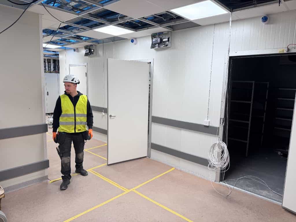 Kylrum med installerade dörrar och tekniker på plats